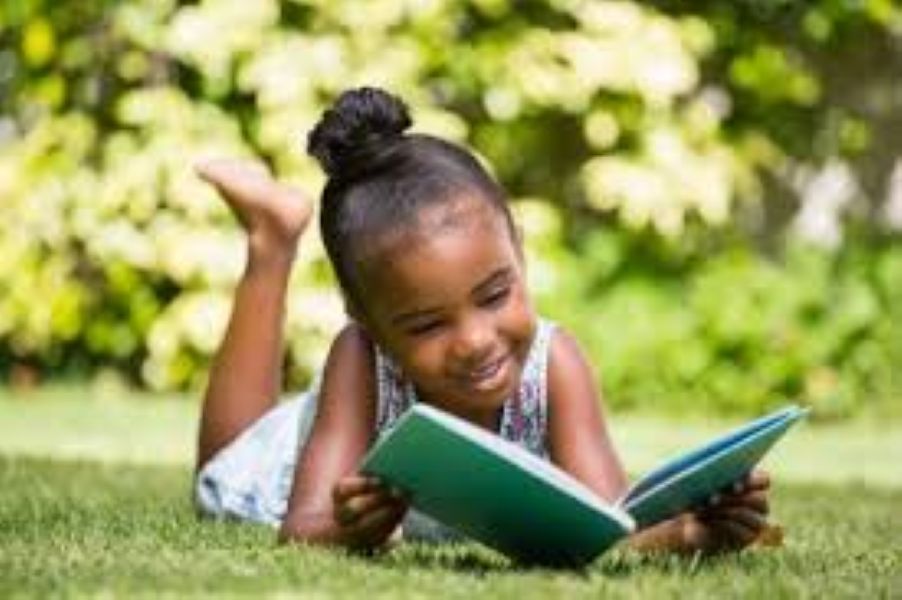 Little girl reading outside