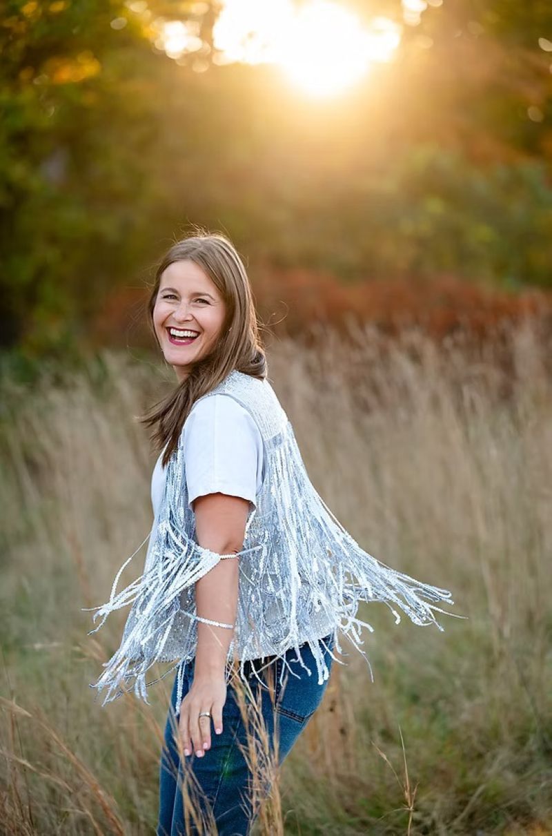 Miss Ari in a field, spinning in her sparkle vest.